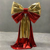A giant satin bow in gold and red with a long tulle drape for event decor.