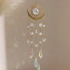 A gold flame moon crystal sun catcher featuring a crescent moon and hanging crystal beads and a star charm.