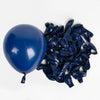 A blue balloon and a pile of navy blue crumpled balloons for party décor.
