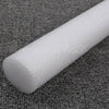 A white foam cylinder used for flower arrangements is shown lying on a dark gray textured surface.