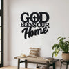 Art mural metal noir avec le texte 'GOD BLESS OUR' fixé sur un mur blanc.