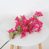 Leuchtend rosa künstliche Bougainvillea-Pflanze mit grünen Blättern auf weißem Tisch.