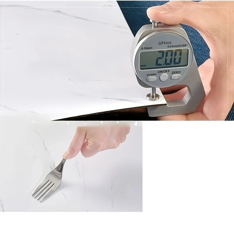 A hand holds a digital caliper measuring a white marble tile, showing a reading of 2.00 mm.