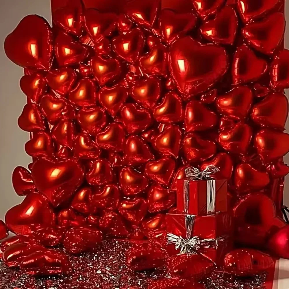 A dense arrangement of shiny red heart-shaped foil balloons covering a surface.
