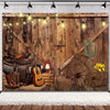 A rustic wooden barn door backdrop featuring a cowboy theme with leather goods, tools, and a cactus.