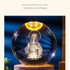 A clear crystal ball night light featuring a figure inside, illuminated with a warm glow.