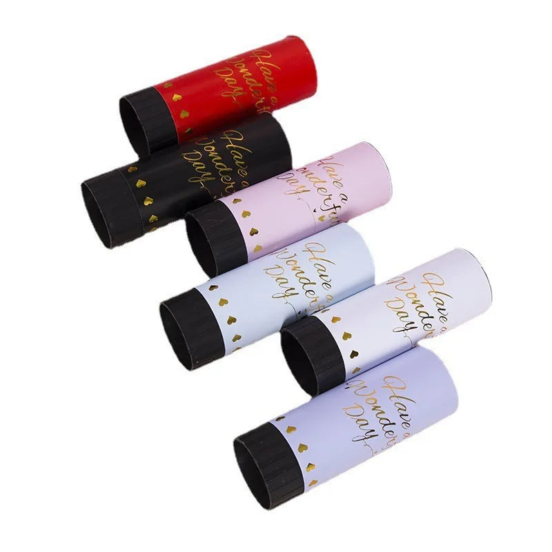 A collection of red and pink hand twist confetti cannons for parties.