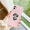 Une main tient un smartphone rose avec un pack d'autocollants de crâne gothique, sur fond extérieur vert flou.