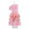 Pink glitter number one candle decorated with a pink bow for a birthday or anniversary