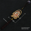 A wooden Our Lady of Guadalupe pendant charm with a gold-colored frame and tassel on a black background.