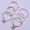 A set of six beaded bracelets featuring various colors and a heart charm on a light purple background.