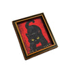 A framed picture of a black cat with yellow eyes on a red background, suitable for refrigerator decor.
