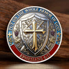 A commemorative coin featuring a silver-plated cross design and text from Ephesians 6:11, set against a wooden background.