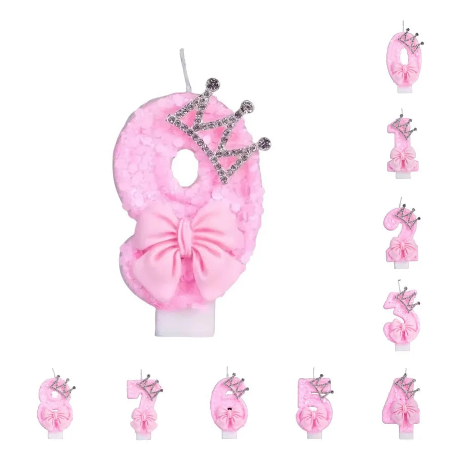 A set of pink princess birthday candles with crown toppers and bows for cake decoration