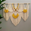 Handwoven boho macrame wall hanging tapestry featuring cream colored cords and yellow tassels