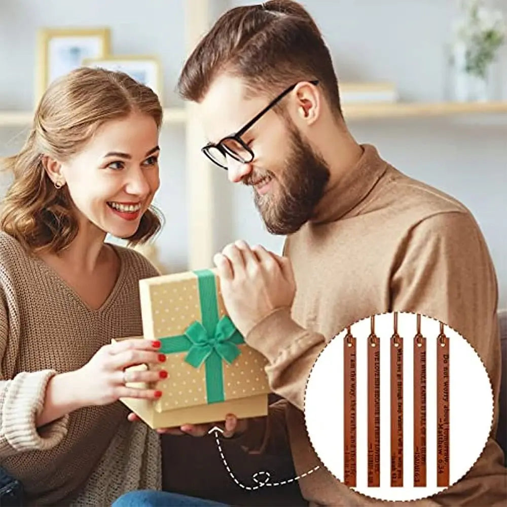 A woman and man looking at premium leather bible bookmarks with a green ribbon.