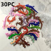 A collection of 30 individually colored, 3D printed articulated lizard figurines arranged in a scattered pattern on a white m