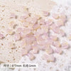 A pile of translucent pink cat head glass beads for jewelry making resting on white foam.