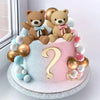 A pink and white cake decorated with teddy bear toppers for a gender reveal party