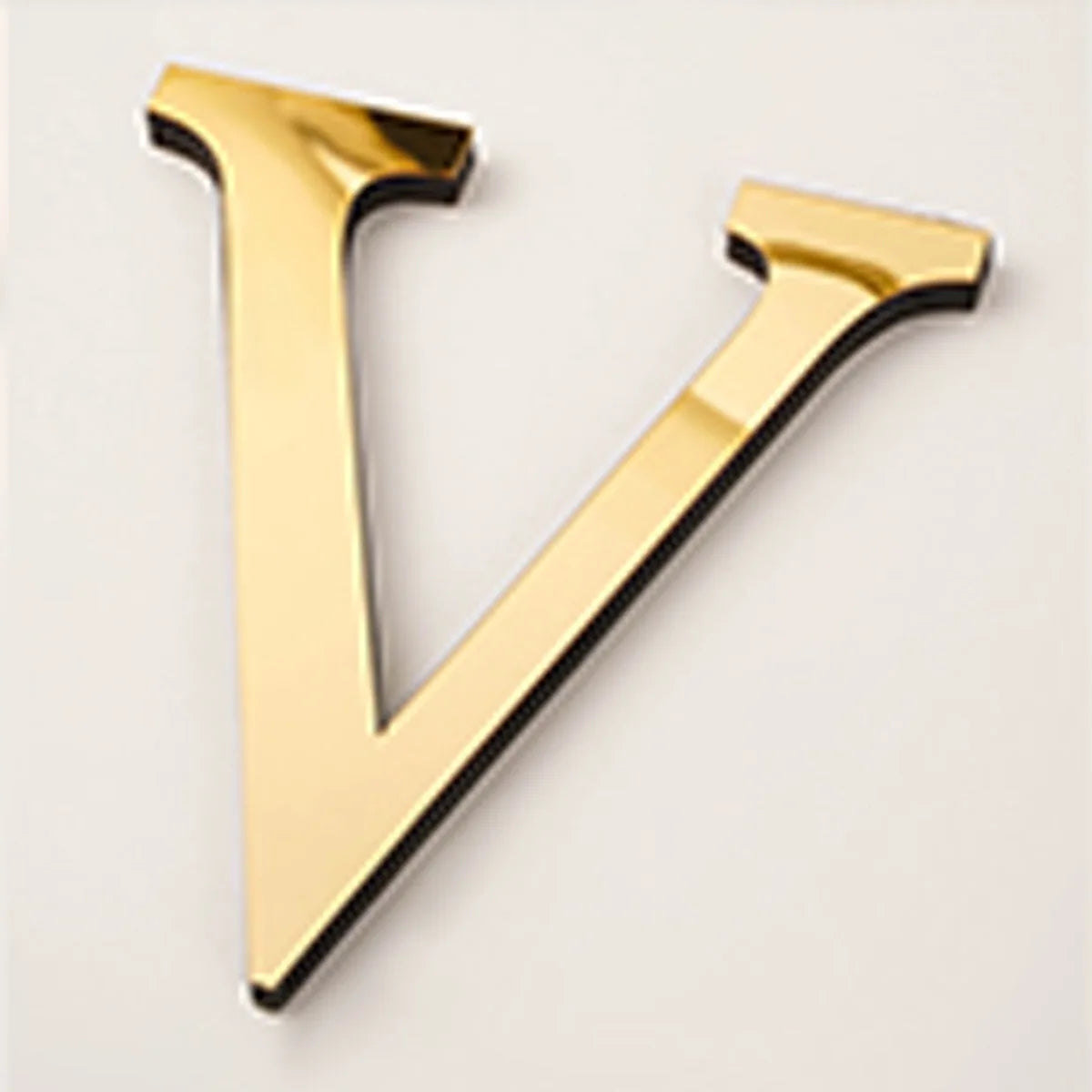 A gold acrylic mirror letter V shape wall sticker for decorative purposes.