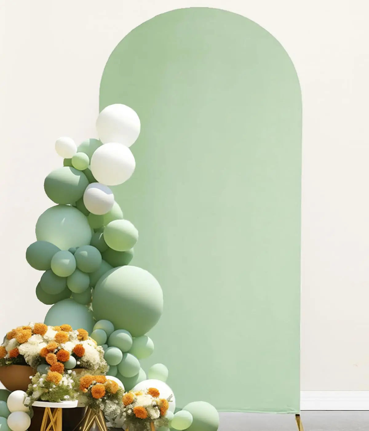 A floral and balloon arrangement against a pale green arched backdrop cover.