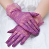 Purple sheer lace gloves worn on a hand against a white background.