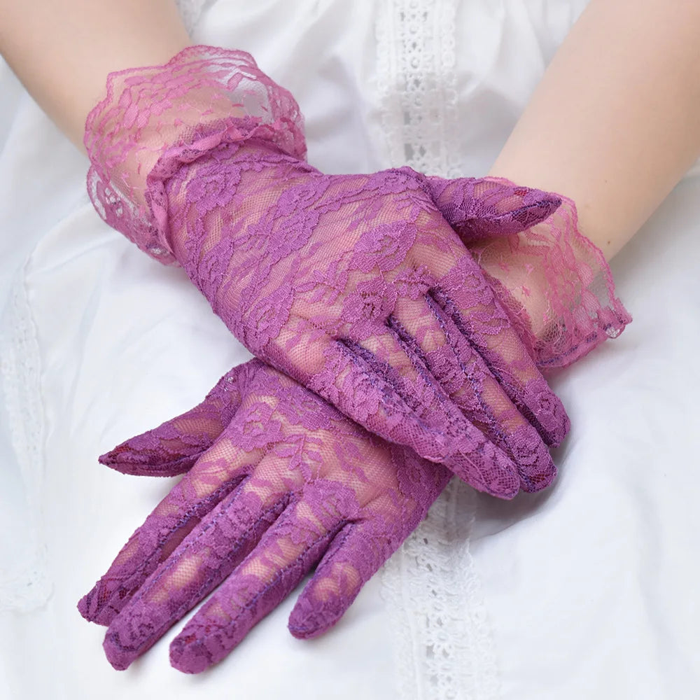 Purple sheer lace gloves worn on a hand against a white background.