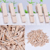 A collection of natural wooden mini clothespins arranged in a row and a pile.