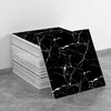 A stack of black and white marble tile stickers, featuring intricate veining, is displayed on a gray surface.