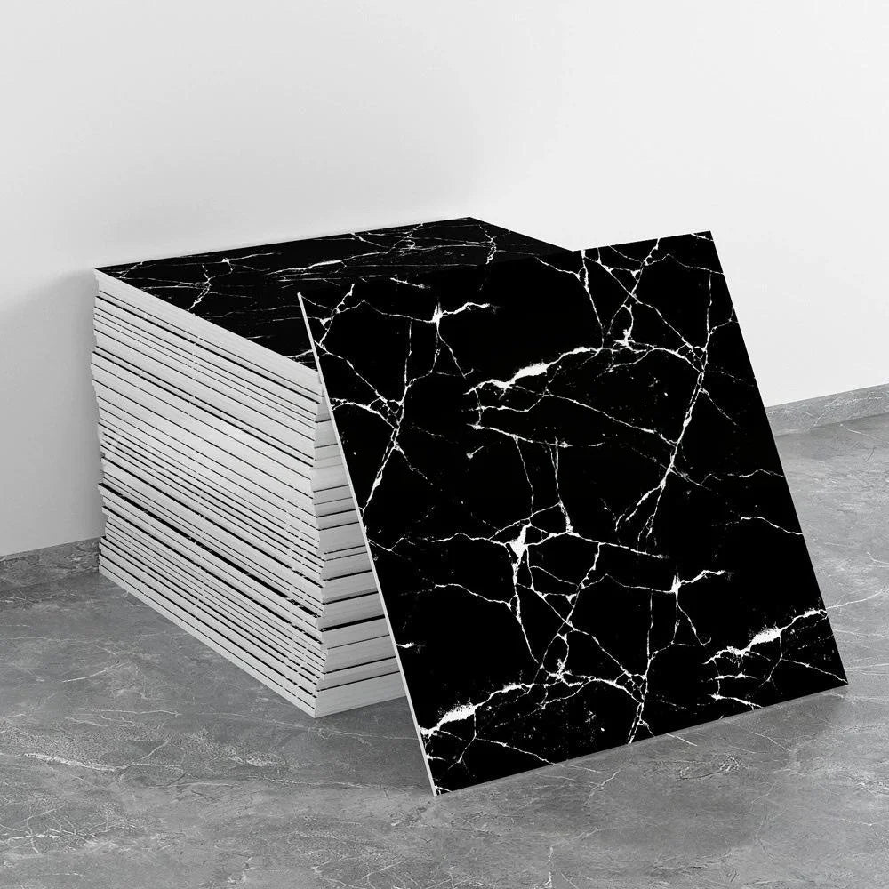 A stack of black and white marble tile stickers, featuring intricate veining, is displayed on a gray surface.