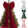 A deep red velvet Christmas tree bow with long draping tails displayed on a decorated evergreen tree.