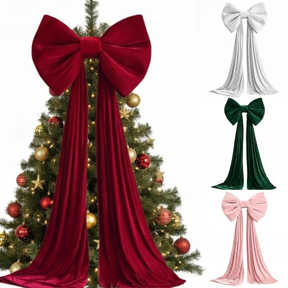 A deep red velvet Christmas tree bow with long draping tails displayed on a decorated evergreen tree.