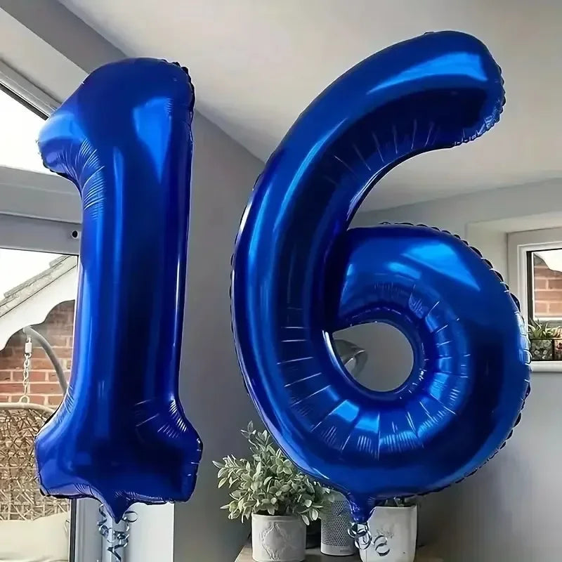 A large, shiny dark blue foil number balloon shaped like the number 16 is displayed indoors.