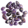 Colección de piedras transparentes moradas y oscuras talladas con runas antiguas.