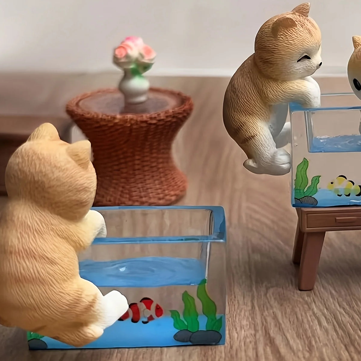 Three adorable cat figurines are displayed alongside a fish tank decor set.