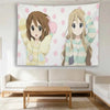Anime wall hanging featuring two female characters in light-colored sweaters against a pink polka dot background