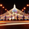 Un gran árbol de Navidad iluminado decorado con miles de luces LED blancas y coloridas por la noche.