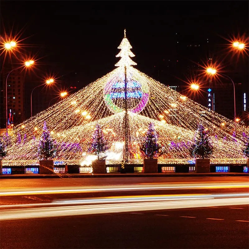 Un gran árbol de Navidad iluminado decorado con miles de luces LED blancas y coloridas por la noche.