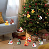 A festive Christmas tree decorated with rubber duck ornaments and wrapped gifts in a living room setting.