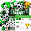 A large balloon arch display featuring various black, white, and green soccer balls and gold trophies for a birthday party.
