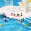A collection of glow-in-the-dark resin cruise duck decorations in various colors arranged on a white platter with a glass cup
