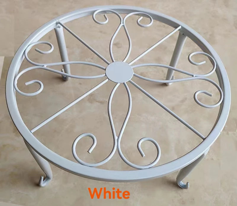 White decorative metal plant stand with a circular saucer design.