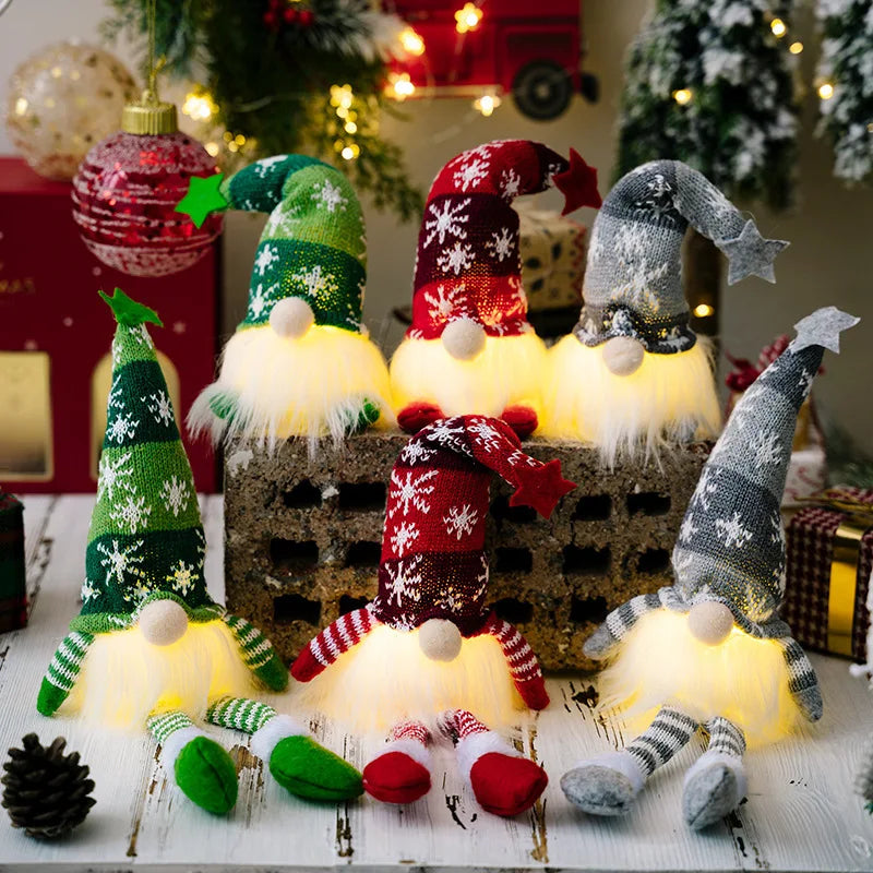 A collection of illuminated LED gnome Christmas decorations featuring faceless dolls with a warm glow and festive holiday col