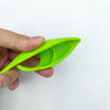 A hand holds a bright lime green realistic latex elf ear product.