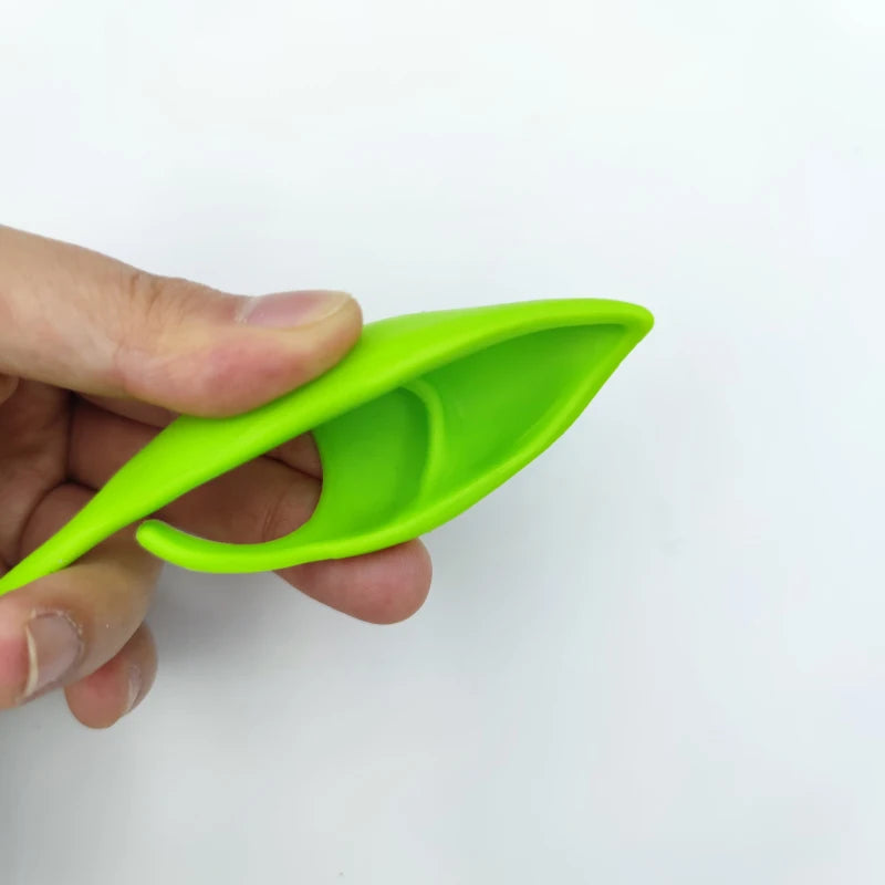 A hand holds a bright lime green realistic latex elf ear product.