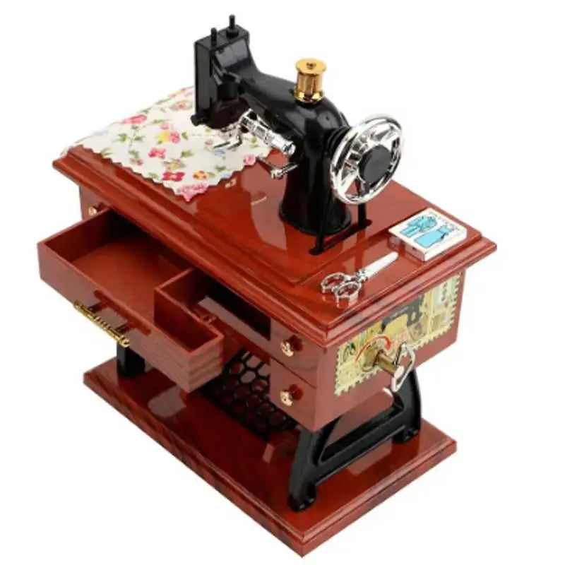 A vintage sewing machine music box decorative ornament with a dark wooden base and brass accents.