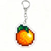 Acrylic keychain charm shaped like a bright orange fruit with green leaves