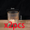 Two vintage striped glass votive candle holders sitting on a wooden surface.