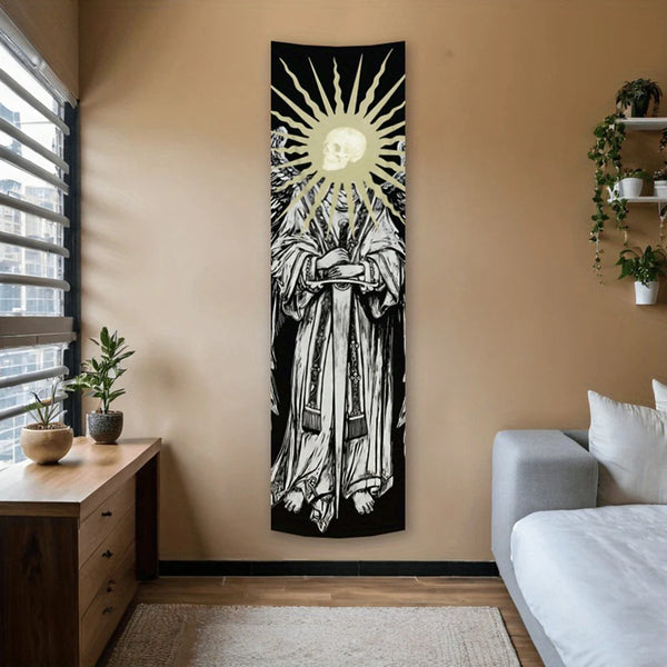 A vertical black and white tapestry featuring a skull radiating sun rays, hanging on a beige wall.