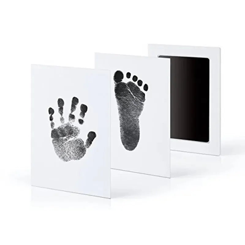 A set of three framed prints featuring black ink pet paw prints on white paper.